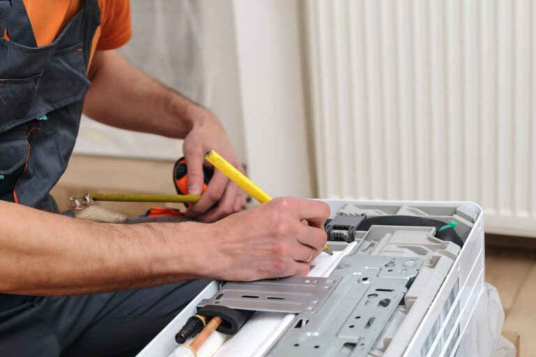 An HVAC technician midway through an HVAC heat pump install