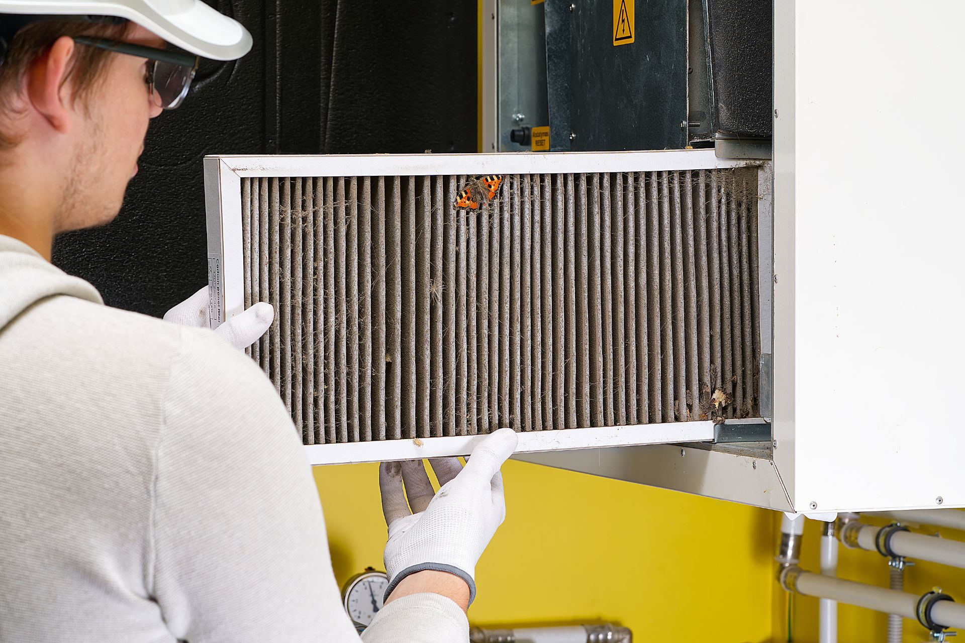 An HVAC technician checking HVAC filter