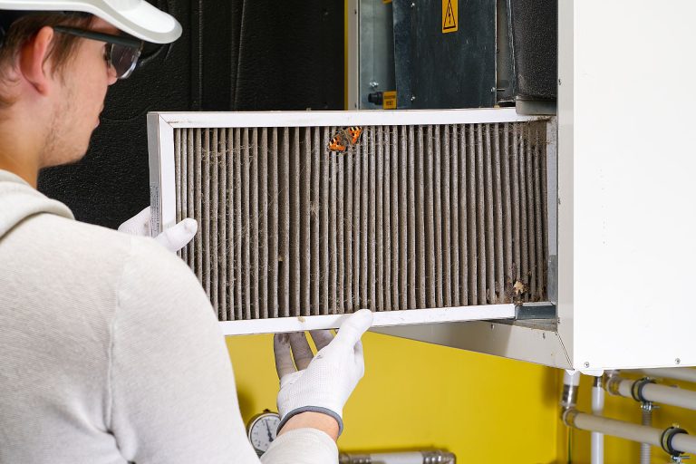 An HVAC technician checking HVAC filter